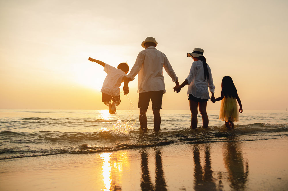 Rodzina na plaży podczas zachodu słońca latem